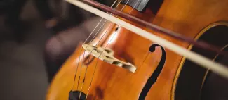 Mid-section of female student playing double bass