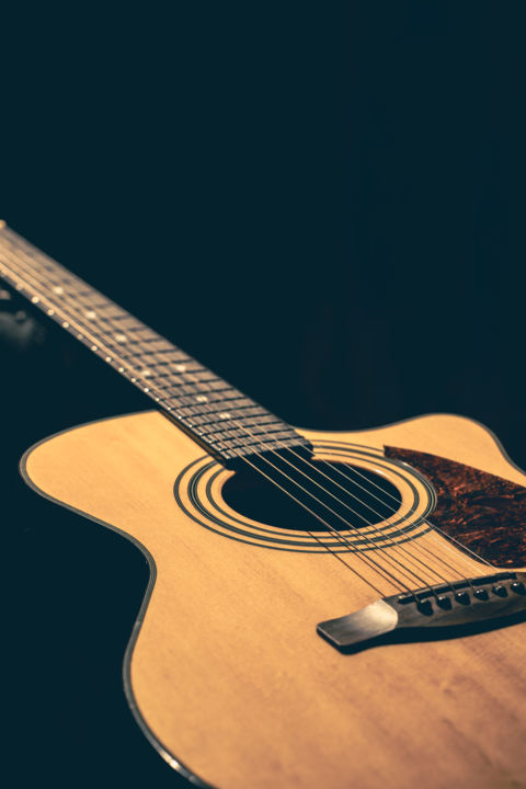 Musical background with acoustic guitar close up.