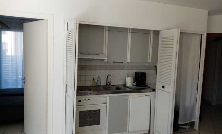 Appartement 4 personnes à Larmor-Plage avec un coin cuisine comprenant lave-linge, four micro-ondes, 2 plaques de cuisson et un réfrigérateur (Morbihan, 56)