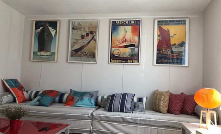 Mobuchon - Le salon et pièce de vie, avec canapé, déco et affiches sur le thème maritime, de la location pour 4 personnes, à Port-Louis, proche Lorient Bretagne Sud (Morbihan, 56)